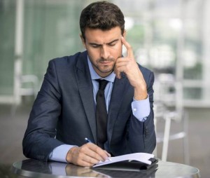 Focused businessman thinking and writing outside office